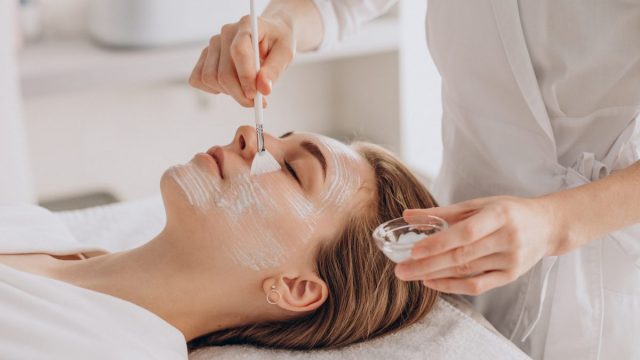 Cosmetologist Doing Face Treatment Applying Face Mask