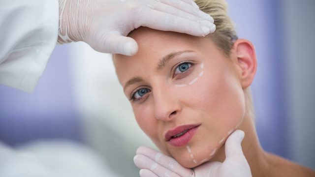 Doctor Examining Female Patients Face Cosmetic Treatment