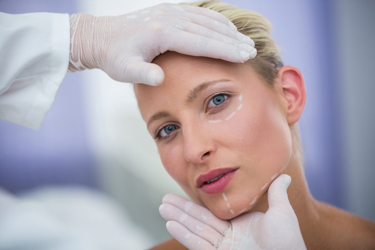 Doctor Examining Female Patients Face Cosmetic Treatment