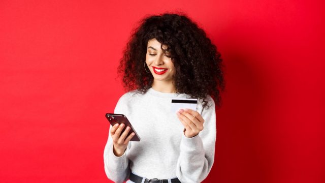 E Commerce Online Shopping Concept Attractive Caucasian Woman Paying Purchase Internet Holding Smartphone Credit Card Red Background