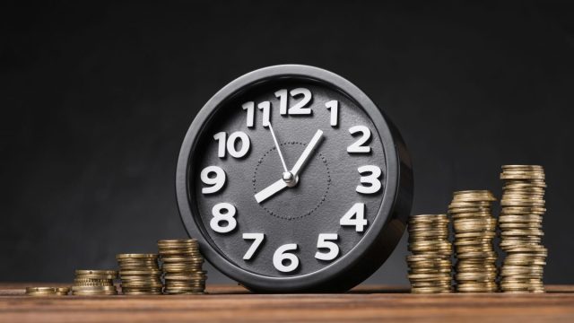Freepik.com Round Clock Increasing Coins Wooden Desk Against Black Backdrop